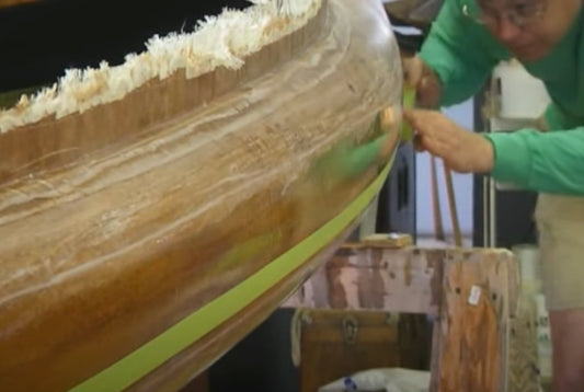 Applying a fill coat of resin to a wooden boat.