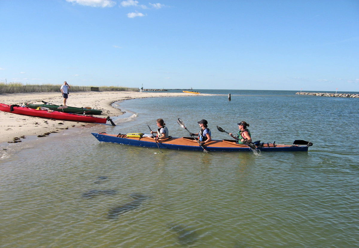 A trio of paddlers in sync as they head for the beach in this Chesapeake Triple built by Jason R.