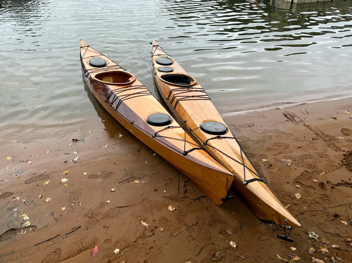 Two stitch-and-glue Petrel Play kayak. To the left is the SG model and the Petrel Play SGL model is to the right.