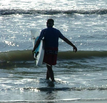 A surfer taking his San O' Paddleboard into the waves.