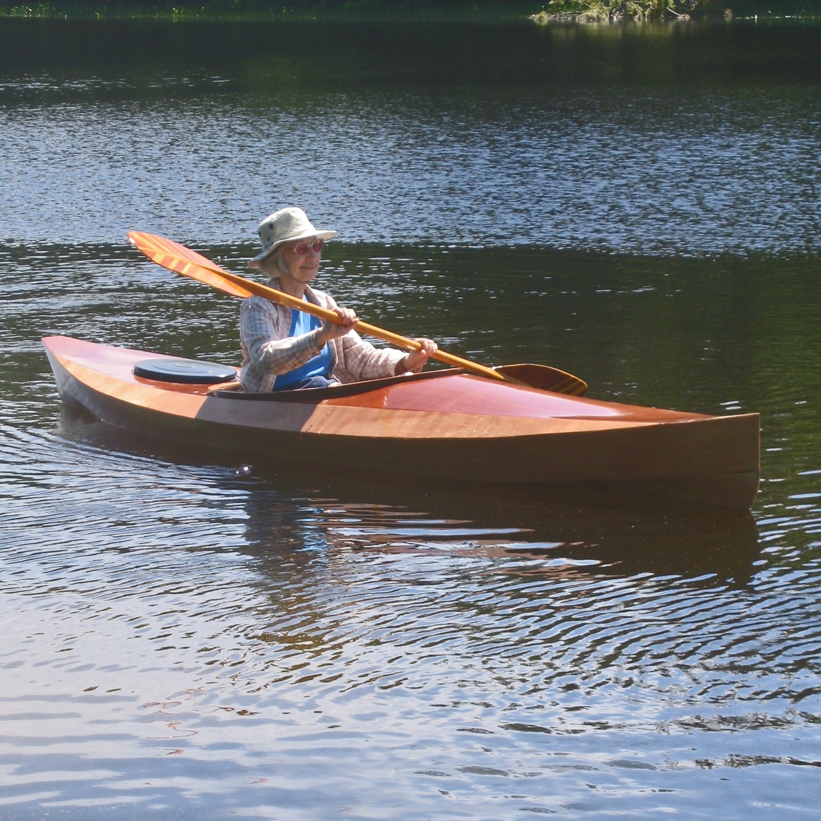 A woman paddling a Wood Duck 12 kayak