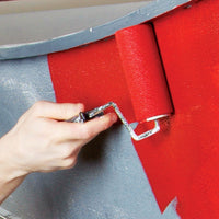 Rolling Red paint on to a primed boat hull