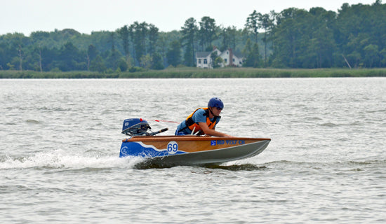 Ed W. leans over the bow of BLUE WAVE to get his Cocktail Class Racer to plane better.