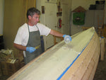 After the fiberglass is laid on the bottom of the Annapolis Wherry Tandem hull, the builder pours epoxy on to adhere and seal it.  Thumbnail