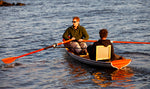 A man rowing an Annapolis Tandem Wherry with a passenger in a cane seat Thumbnail