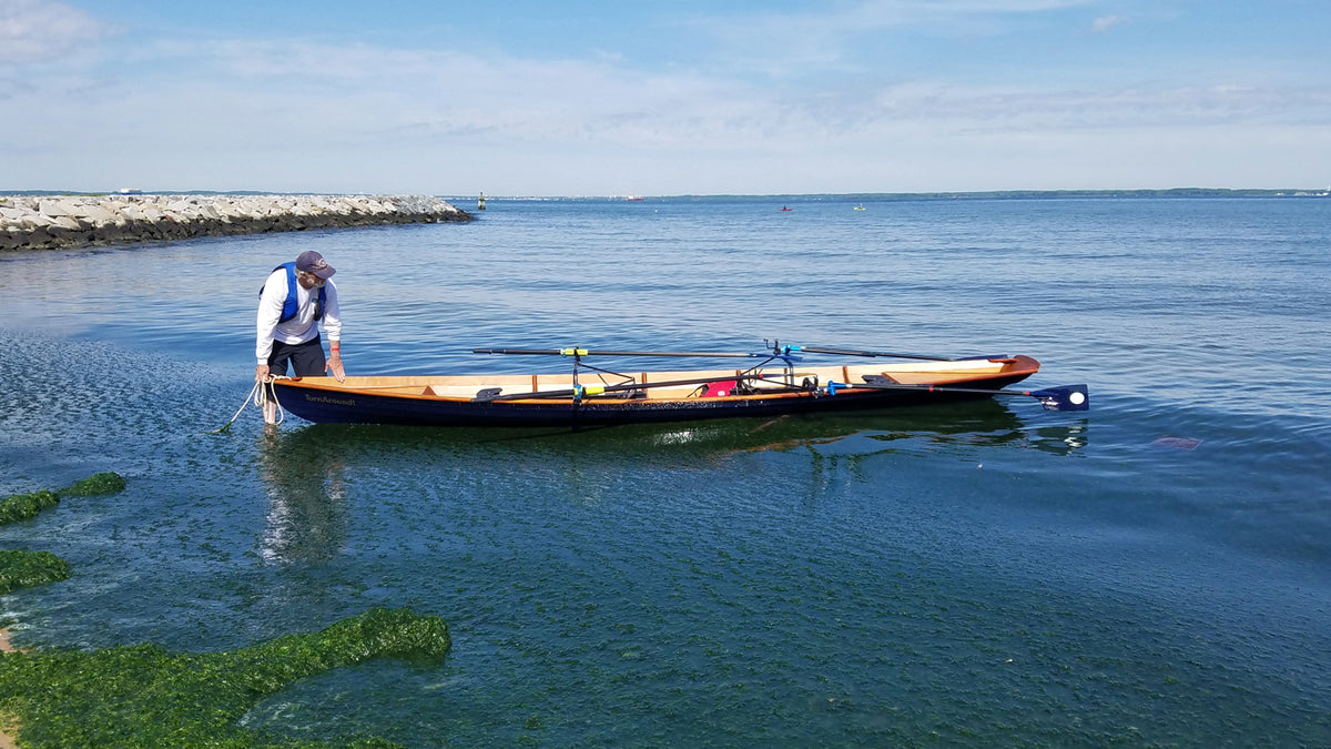 Joe Y launching an Annapolis Wherry Tandem at Matapeake Beach on the Chesapeake Bay