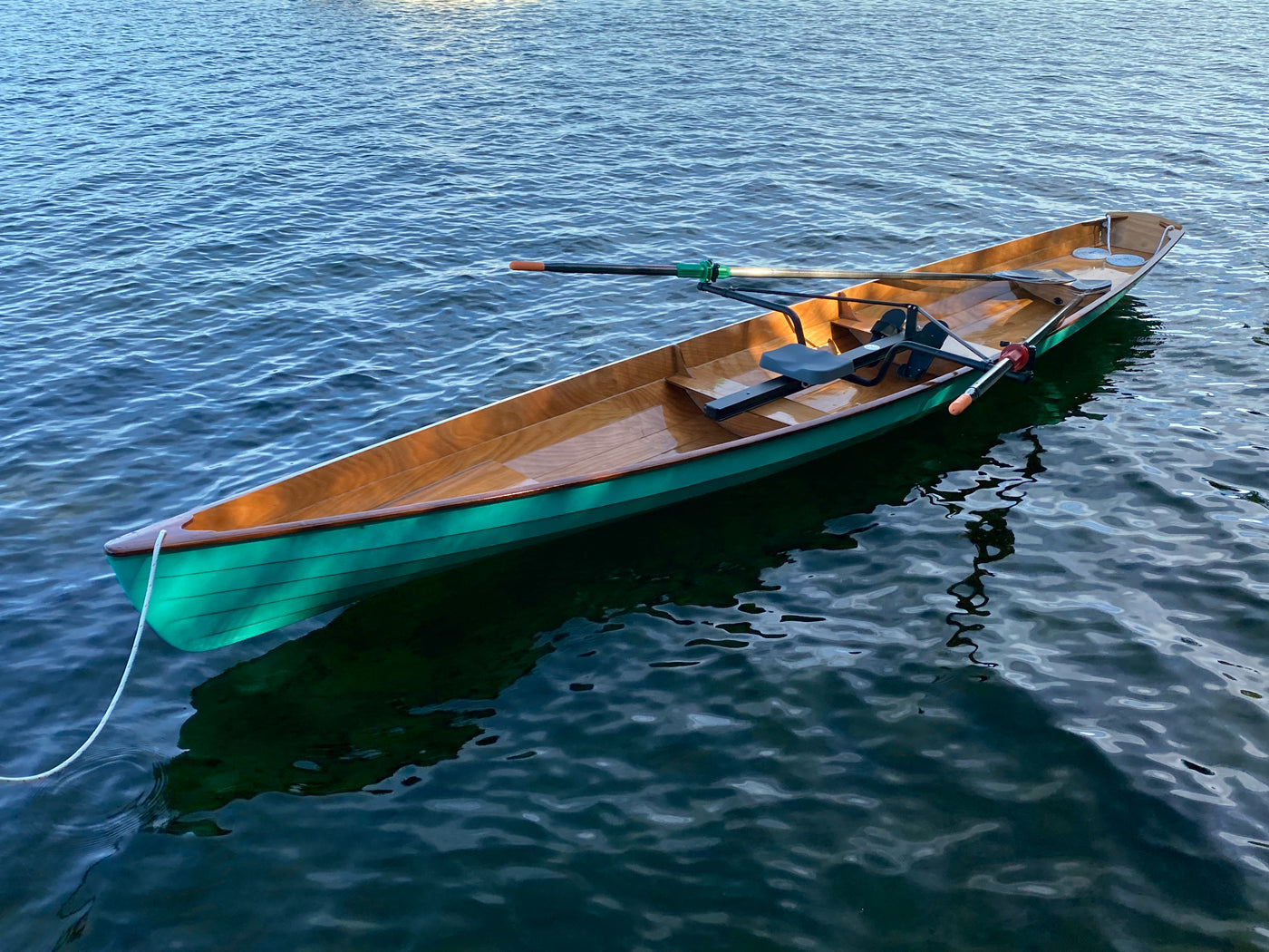 A green Annapolis Wherry built by Tim M, floating on Thompson Lake, Portland, Maine 
