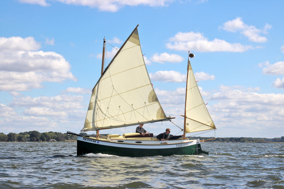 John Harris making an adjustment to the rig of a lug-rigged Autumn Leaves Canoe Yawl.