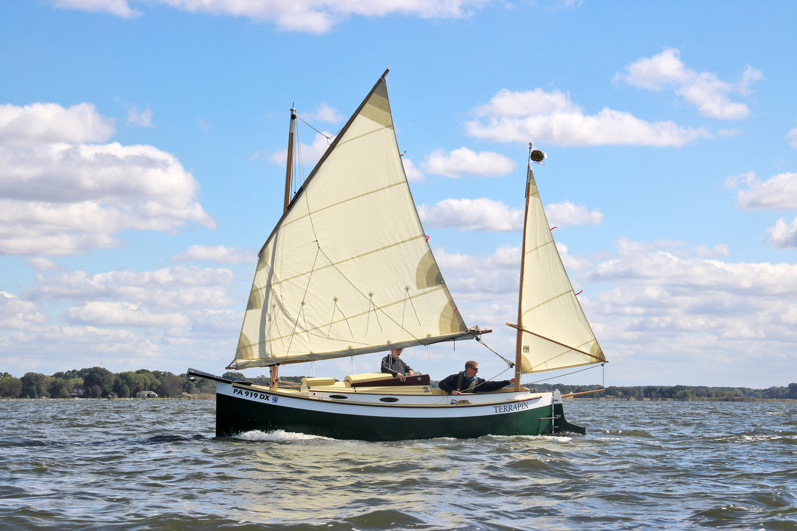 John Harris making an adjustment to the rig of a lug-rigged Autumn Leaves Canoe Yawl.