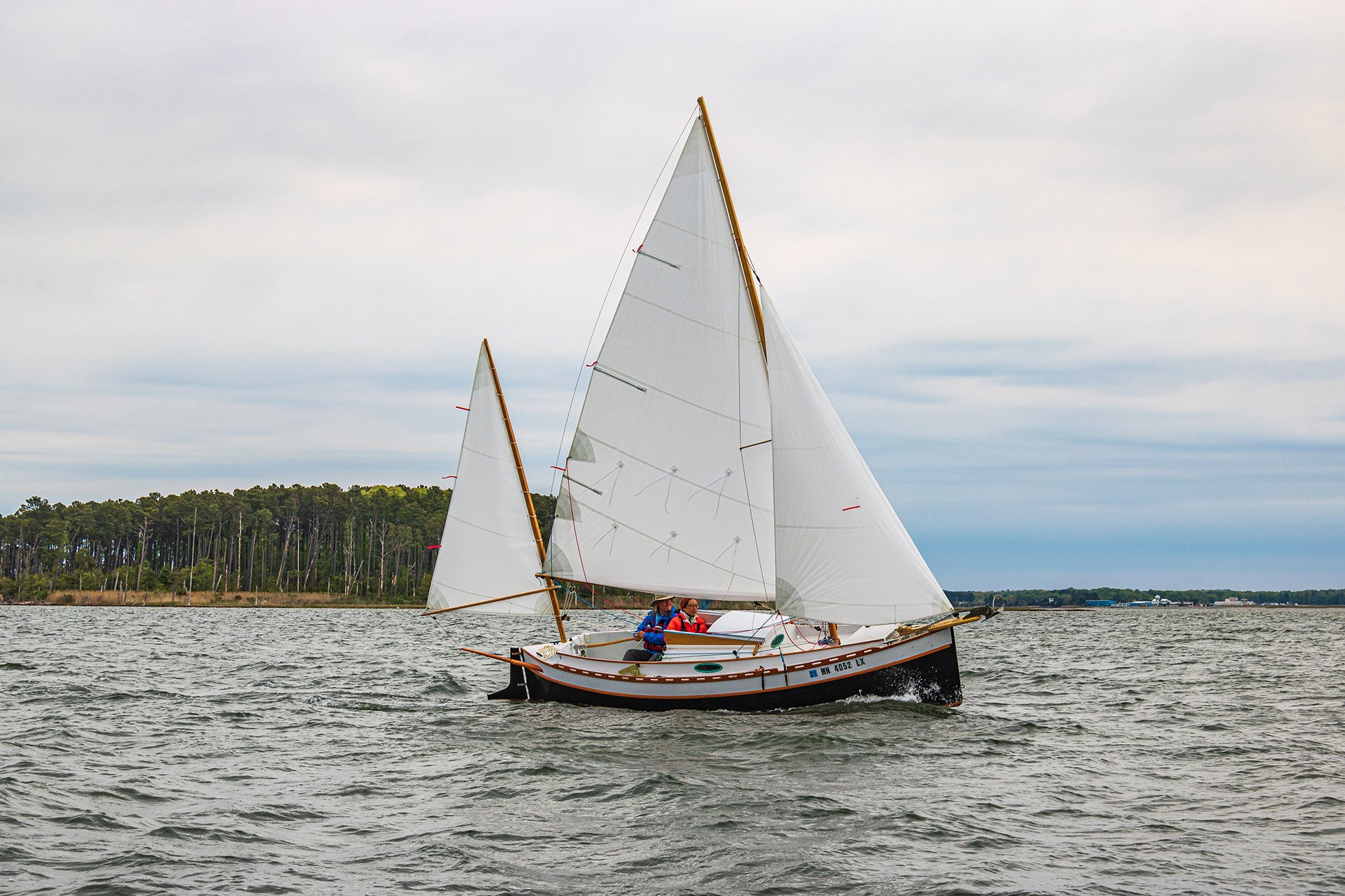 standard-rigged Autumn Leaves canoe yawl under full sail.