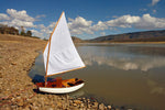 Eastport Pram built by Andres S. has pulled up on a rocky beach. Thumbnail