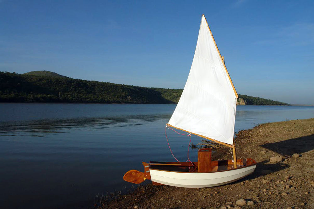 With board and rudder up, this Eastport Pram rests comfortably on the shore in Jalisco, Mexico.