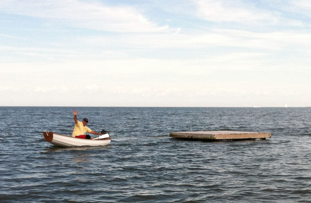 George C. sent this image of him towing an 800 lb. dock with his Eastport Pram powered by a 2.4-hp outboard.