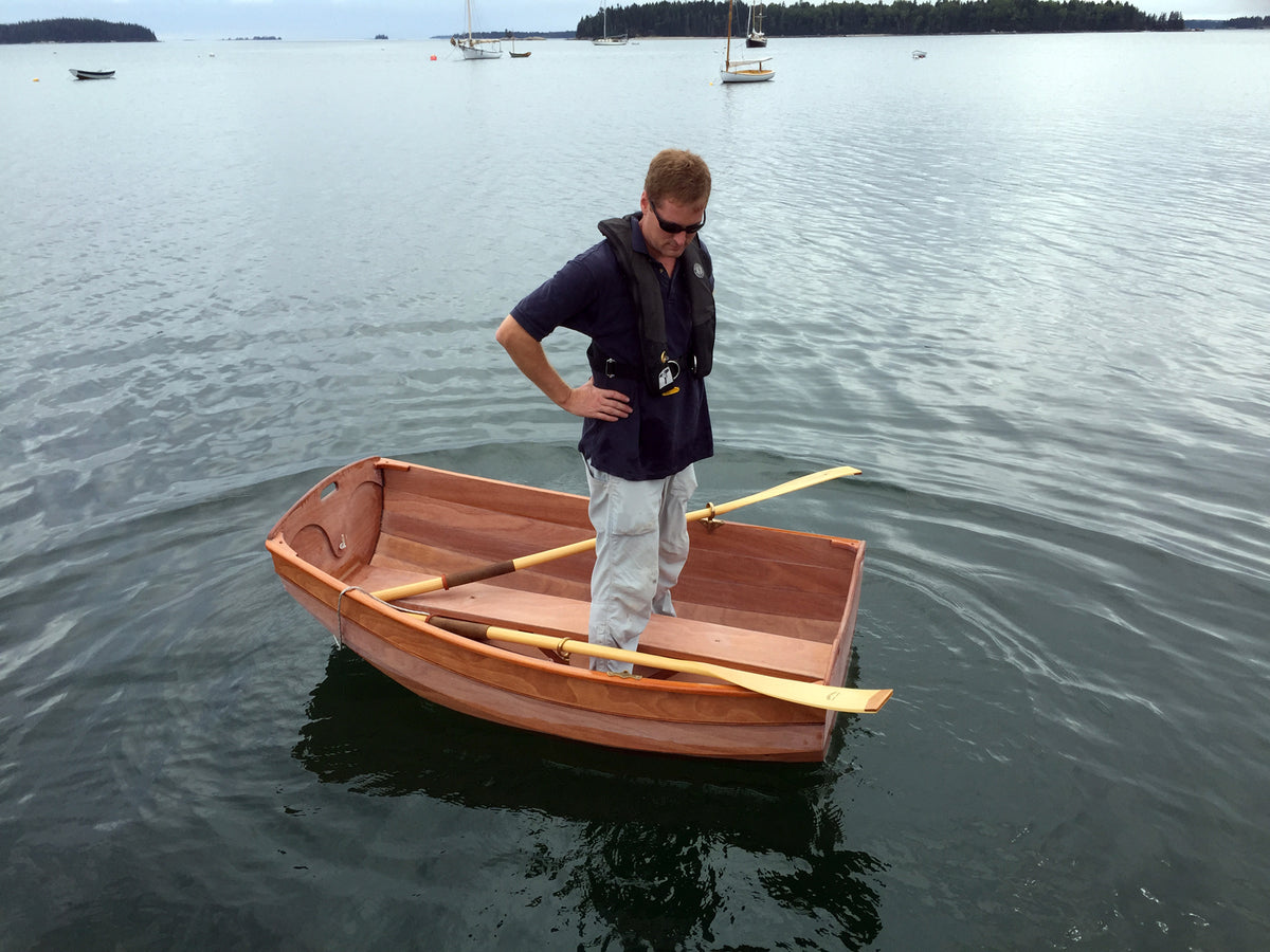John H. stands carefully in the Eastport Ultralight Dinghy to demonstrate stability. 
