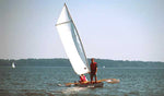 The CLC SailRig adds great stability to a canoe or kayak as seen in this image of a man standing up in a tandem kayak while it is under sail. Thumbnail