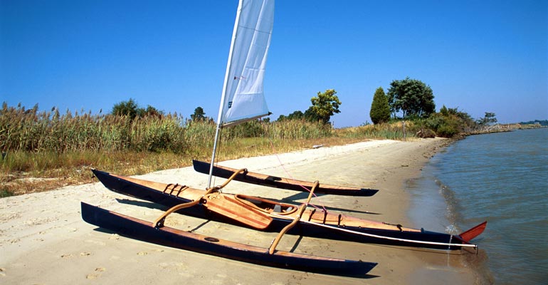  CLC SailRig attached to a kayak awaits launch on a Maryland beach.