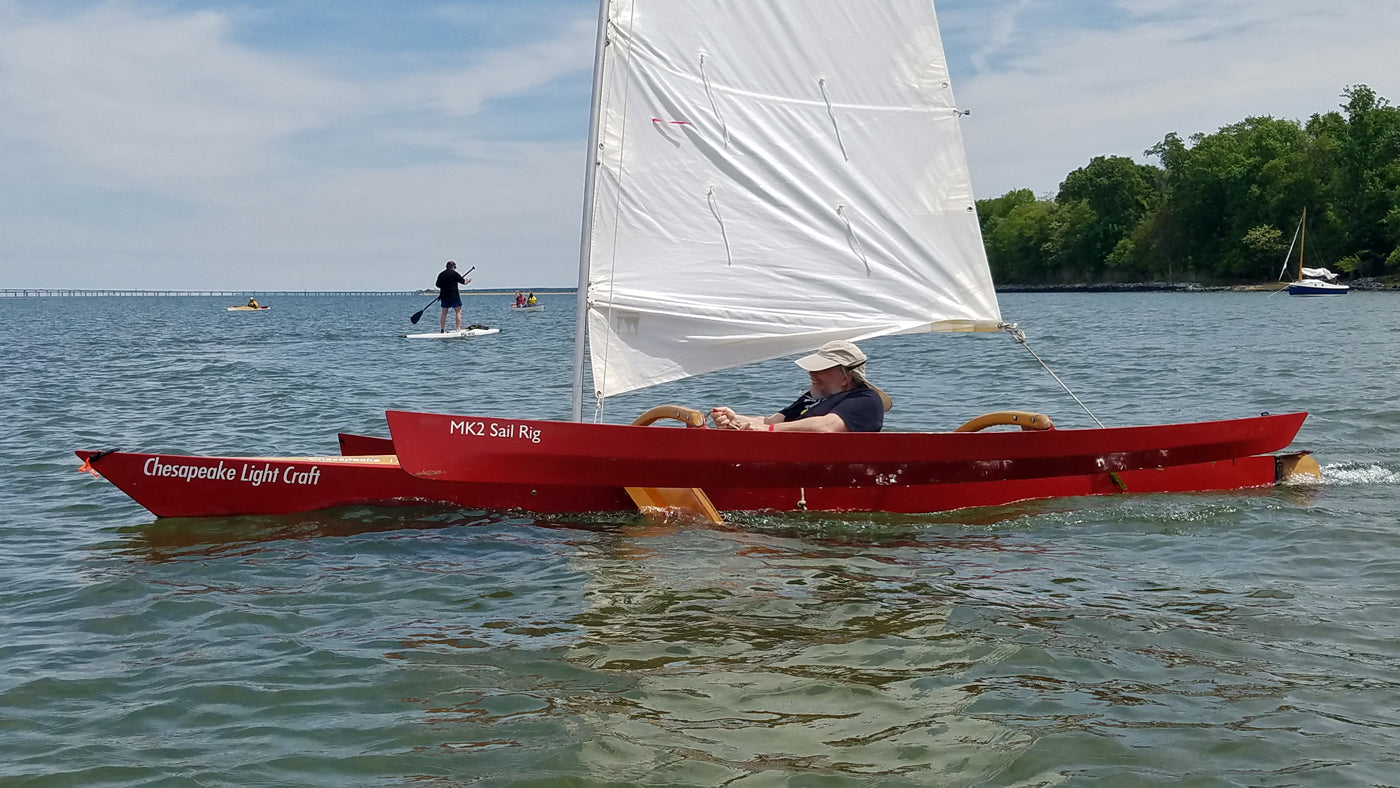 One can just see the leeboard peeking out below the windward ama as this sailor is enjoying a fast ride under a  CLC SailRig.