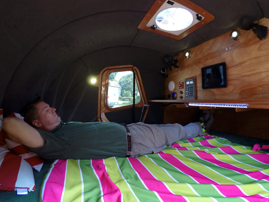 john laying down inside teardrop camper