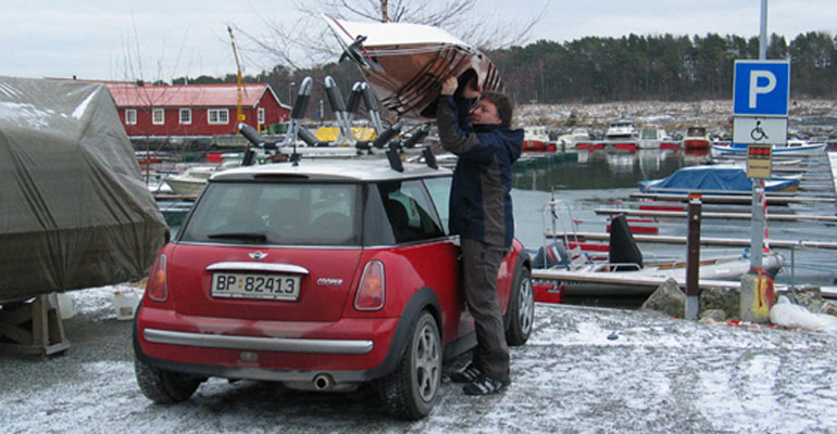 Hoisting a Chesapeake 16 wooden kayak onto the roof of a Mini in a winter boatyard