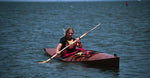 A woman enjoying a paddle in a Chesapeake 16 wooden kayak on the Chesapeake Bay Thumbnail