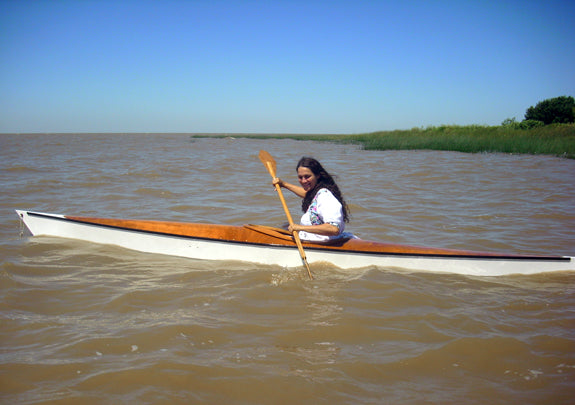A woman paddling a Chesapeake 16 wooden kayak built by Pablo S. on the Rio Del La Plata in Argentina