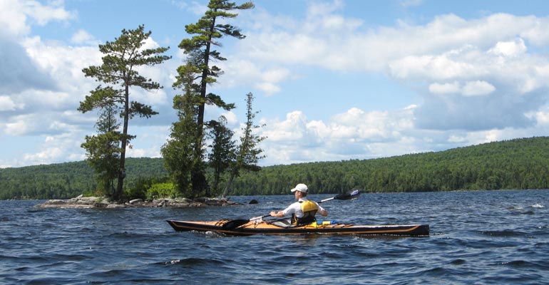 Paddling a Chesapeake 17LT built by Joe F. past a rocky islet