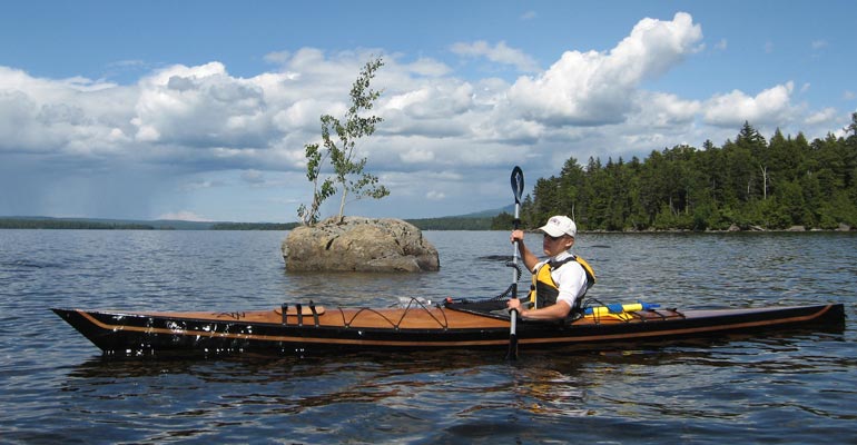Joe F. paddling his finely detailed Chesapeake 17LT wooden kayak on northern waters