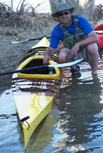 A man and his Chesapeake 17LT wooden kayak at the water's edge Thumbnail