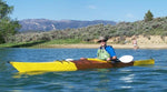 A man paddling a Chesapeake 17LT wooden kayak with striking yellow paint accents Thumbnail