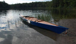 A blue hulled Chesapeake 17LT wooden kayak pulled up among the grasses at the water's edge Thumbnail