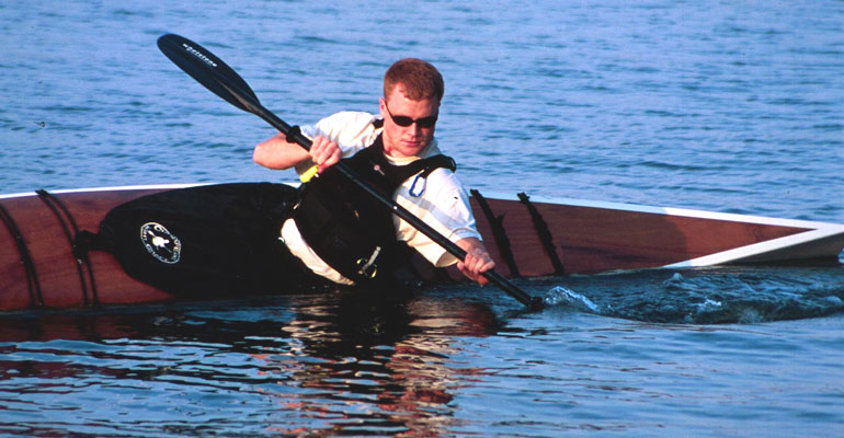 A man bracing a Chesapeake 17LT wooden kayak