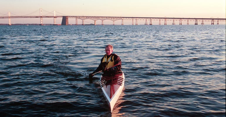 Paddling a Chesapeake 17LT wooden kayak on the Chesapeake with the Bay Bridge in the background