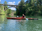 Paddling a Chesapeake 17LT wooden kayak built by Chris S. in front of a high bridge on Estacada Lake in Oregon Thumbnail