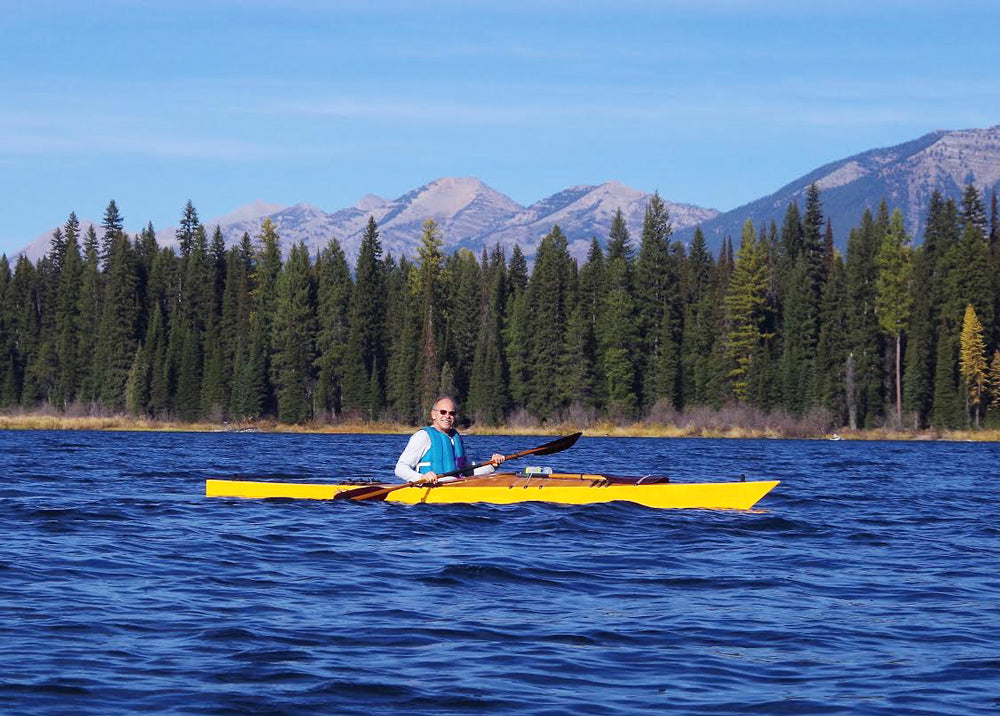 Paddling a yellow-hulled Chesapeake 17LT wooden kayak built by Dave S. on Lake Alva, Montana