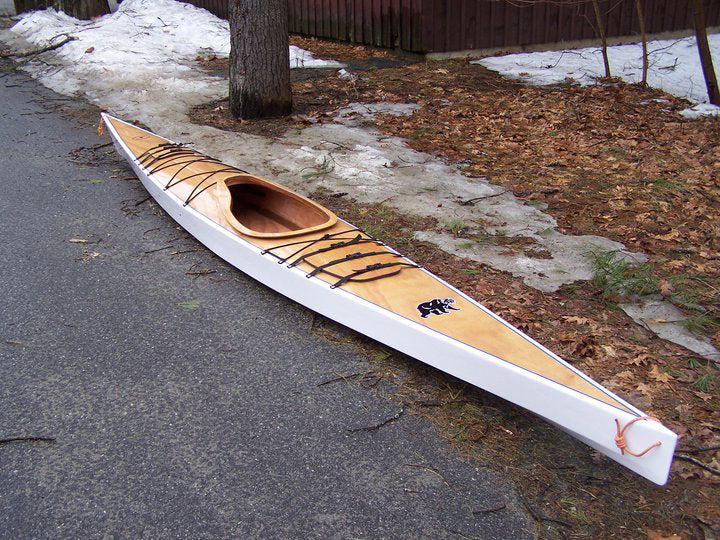 A white-hulled Chesapeake 17LT wooden kayak with bear onlay, built by Nathan L