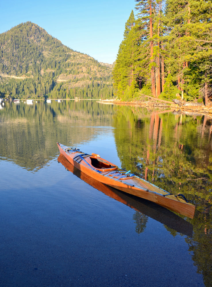A Chesapeake 17LT wooden kayak built by Steve J., floating on the water of Emerald Bay, Lake Tahoe, California