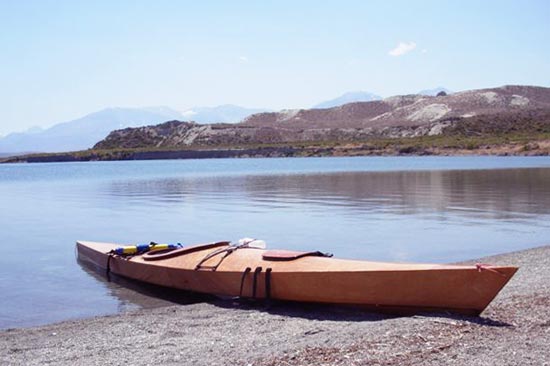 A Chesapeake 17LT wooden kayak built by Kyle H. beached at a mountain lake