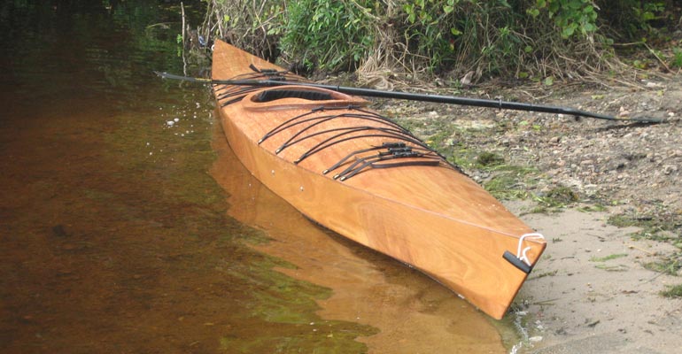 A wooden Chesapeake 17 kayak built by Paul J. at the water's edge