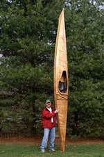 Steve P. showing off his Chesapeake 17 wooden kayak, standing on end in the yard Thumbnail