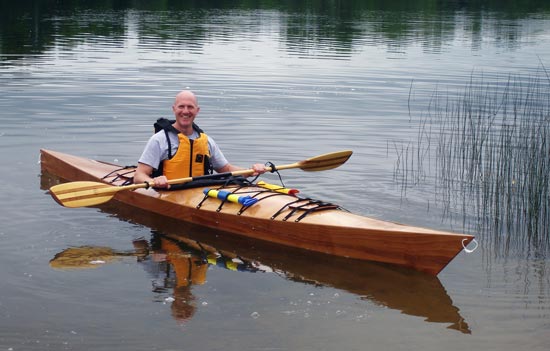A man enjoying the maiden voyage of his Chesapeake 17 wooden kayak