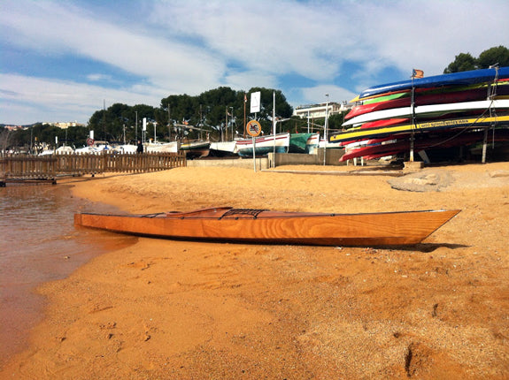 A Chesapeake 17 wooden kayak built by Johan V. on a beach
