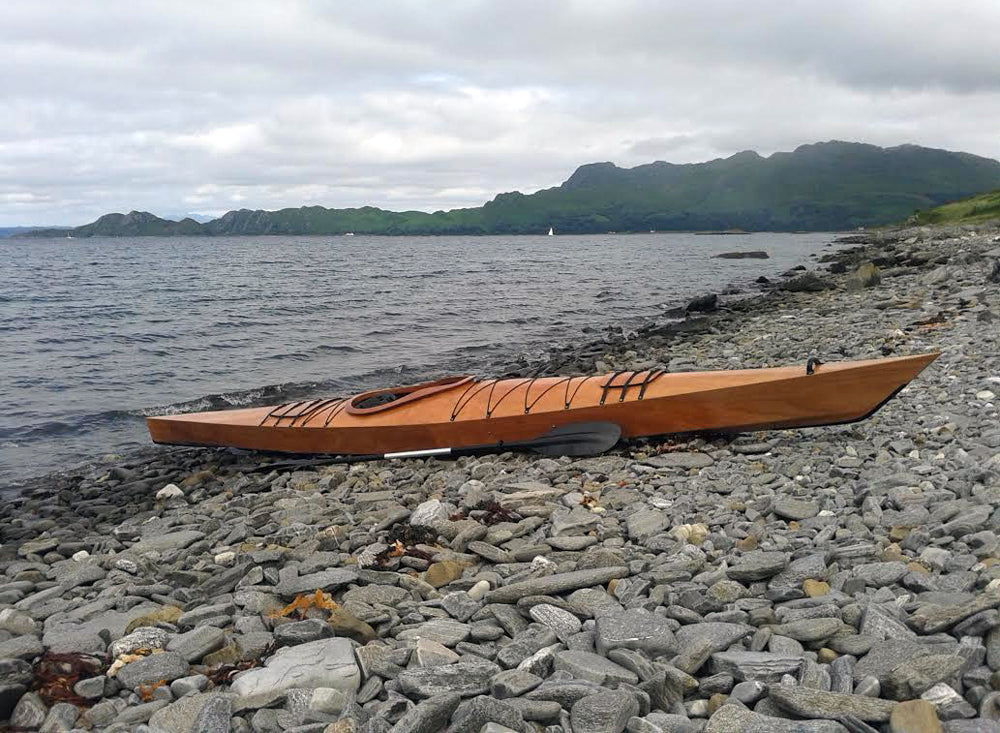 A Chesapeake 17 wooden kayak built by Johann L. on the rocky shore of Loch Nevis, Scotland