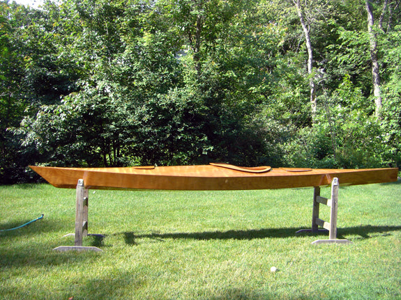 A Chesapeake 17 wooden kayak built by Steven T. on stands in a yard