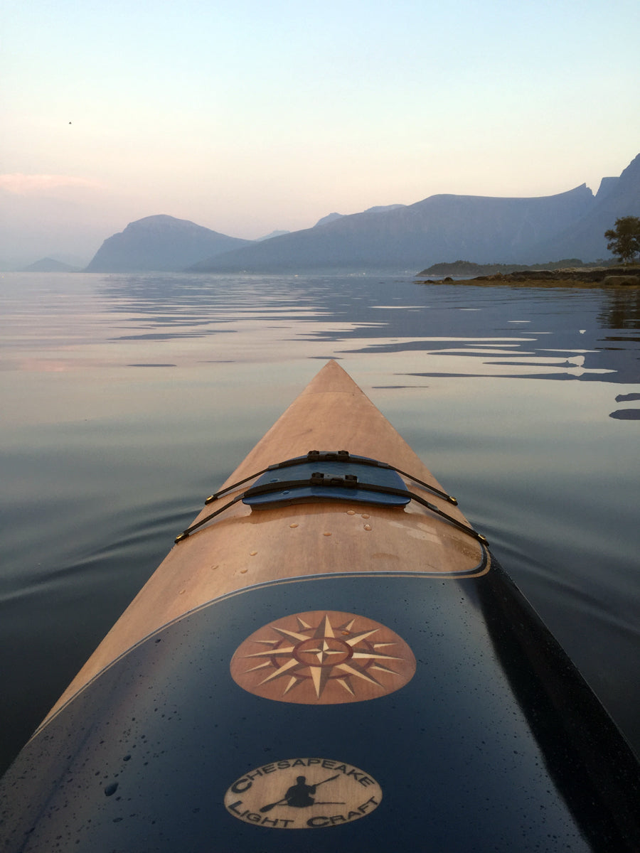A view over the decoratively inlaid bow of a Chesapeake 17 wooden kayak built by Jan N. in Hjorunvaag, Norway