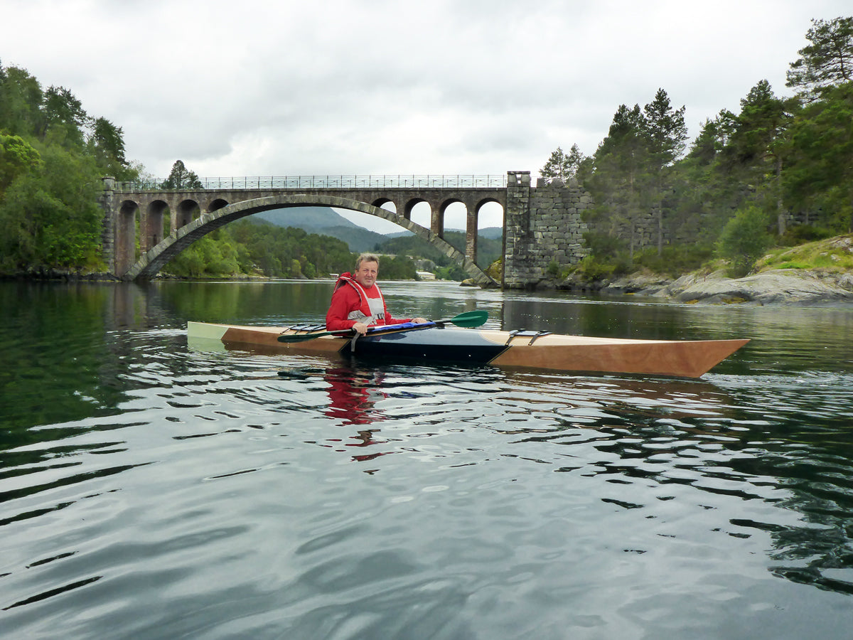 Jan N. paddling his Chesapeake 17 wooden kayak near a bridge in Skodje, Norway