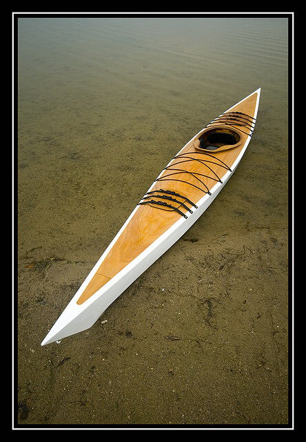 A Chesapeakle 17 wooden kayak built by Rich S. on a sandy shoreline