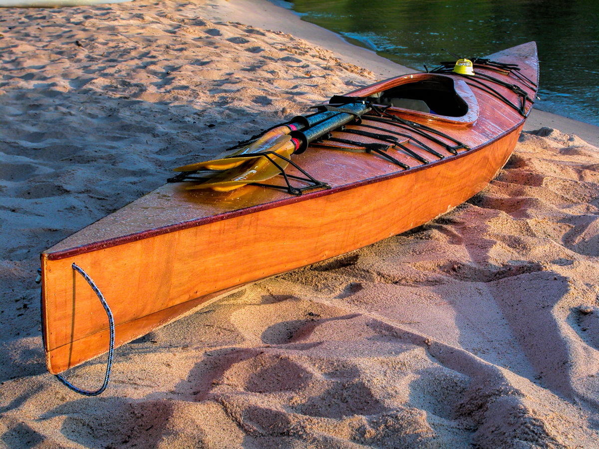 A Chesapeake 17 wooden kayak built by Stan K. on a sandy beach