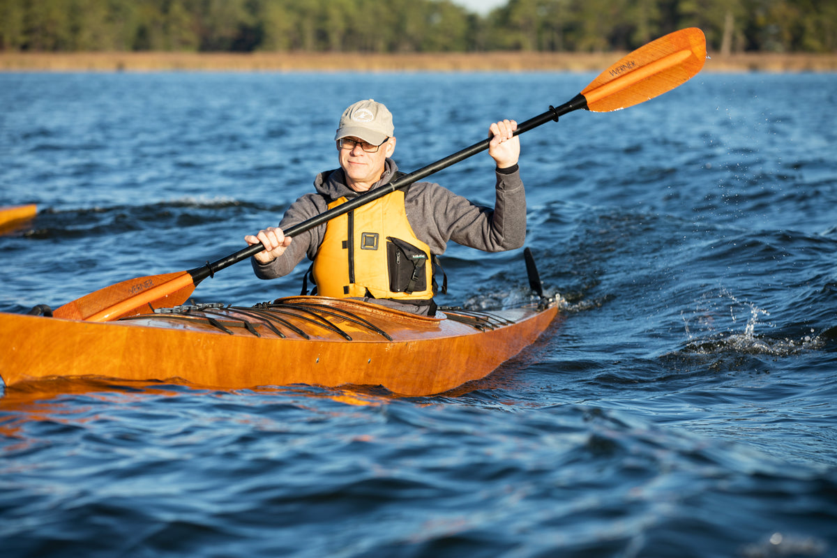 A man enjoying a paddle in a Chesapeake 17 wooden kayak