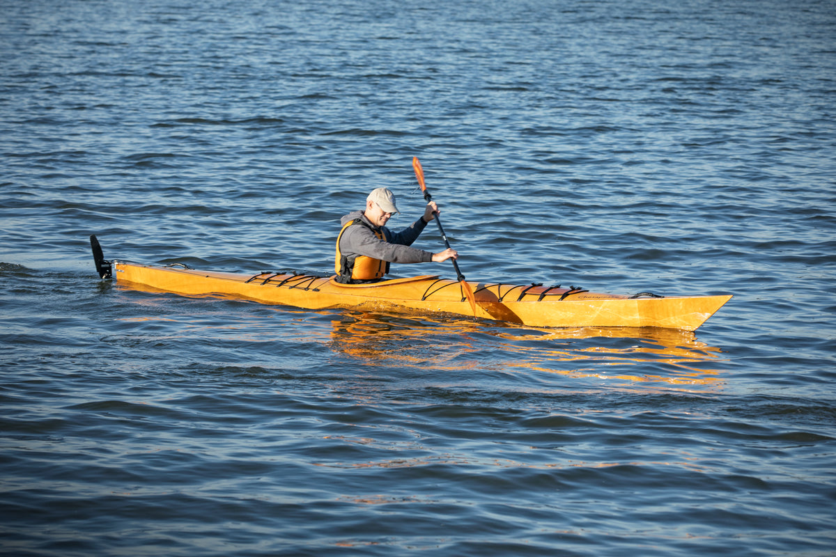 A man paddling a Chesapeake 17 wooden kayak