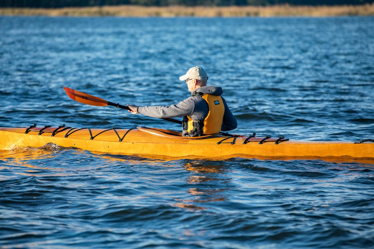 A man paddling a Chesapeake 17 wooden kayak